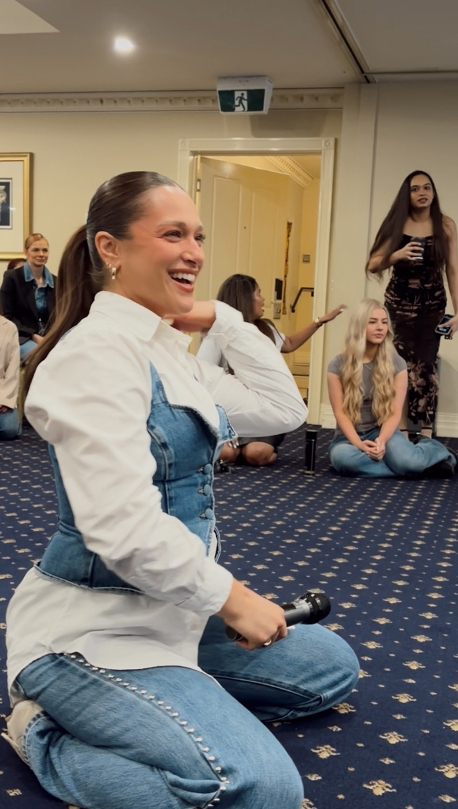 Alexandra Sarandis laughing while facilitating an event with a microphone